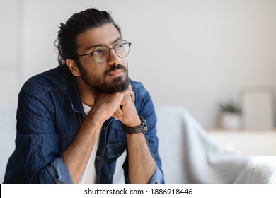 Portrait Of Thoughtful Millennial Arab Guy In Glasses Resting Head On Hands And Looking Aside, Pensive Bearded Eastern Man Thinking About Something, Sitting Deep In His Minds, Copy Space - Shutterstock ID 1886918446