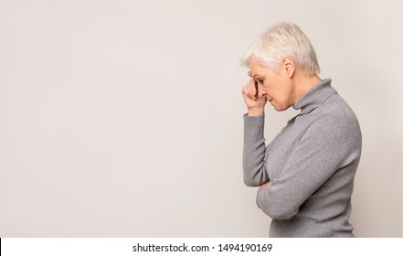 Portrait of thoughtful senior woman on light studio background, panorama with free space