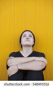 Portrait Of A Thoughtful Teen Lesbian Woman On A Yellow Wall 