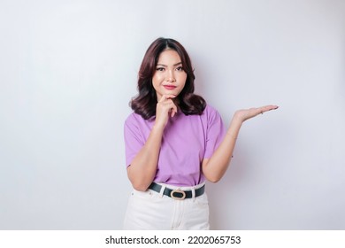 Portrait Of A Thoughtful Young Casual Girl Wearing A Lilac Purple Shirt Looking Aside Isolated Over White Background