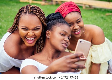Portrait Of Three Beautiful African-american Women Afro Braids Dreadlocks And Turban Taking Pictures Of Yourself On The Phone In The Park At A Picnic,sisters On Vacation