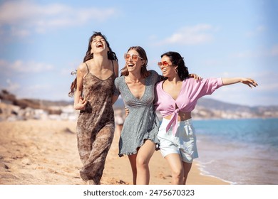 Portrait of three female friends looking at camera on the beach having fun. - Powered by Shutterstock