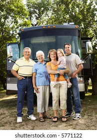 Portrait Of Three Generation Caucasian Family Standing In Front Of Recreational Vehicle Smiling And Looking At Viewer.