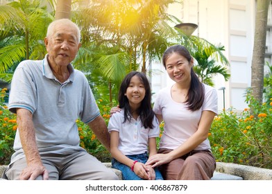 Portrait Of  Three Generation Chinese Family Relaxing At Outdoor Park