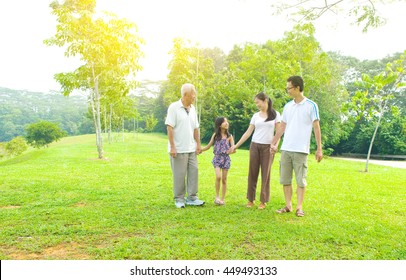 Portrait Of Three Generation Chinese Family Relaxing At Outdoor Park