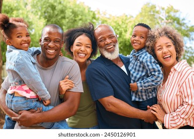 Portrait Of Three Generation Family Outdoors Laughing And Holding Grandchildren In Countryside - Powered by Shutterstock