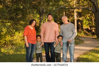 Portrait Of Three Generations Of Mixed Race Family  In Midwestern Park In Autumn