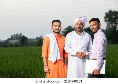 Portrait Of Three Happy Indian Men Standing Together In Agriculture Land Looking On Camera With Laptop, Shaking Hands, Smiling Group Of Males In Field, Blur Background, Skill India, Copy Space.
