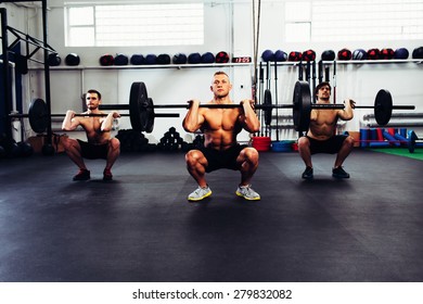 Portrait Of Three Man At Gym Training Clean And Jerk