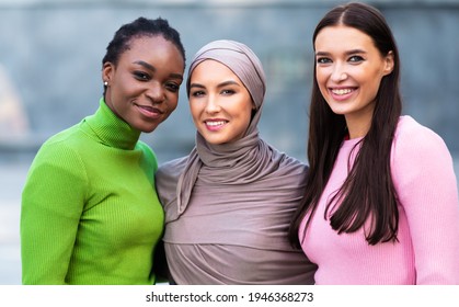 Portrait Of Three Multiracial Young Women. African American, Muslim And Caucasian Ladies Posing Hugging Together Standing Outside, Smiling Looking At Camera. Females Unity And Diversity - Shutterstock ID 1946368273