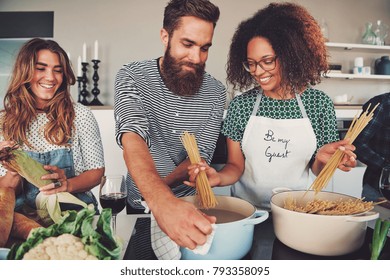 Portrait Of Three People At Kitchen Cooking Spaghetti For Their Dinner Meal