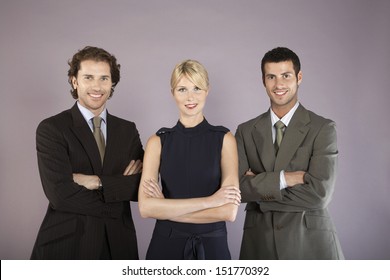 Portrait Of Three Smiling Business People Standing With Arms Crossed Against Purple Background