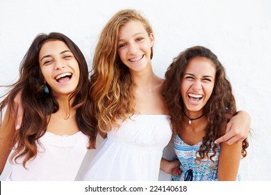 Portrait Of Three Teenage Girls Leaning Against Wall