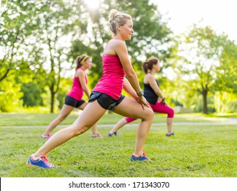 Portrait Of Three Women Streching Their Legs Before Jogging Together