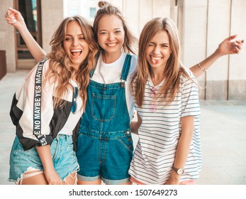 Portrait of three young beautiful smiling hipster girls in trendy summer clothes. Sexy carefree women posing on the street background.Positive models having fun
