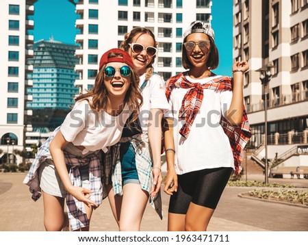 Portrait of three young beautiful smiling hipster female in trendy summer clothes. carefree women posing on the street background.Positive models having fun and going crazy