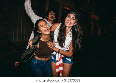 Portrait Of Three Young Friends Having Party Outdoors. Cheerful Young Best Friends Hanging Out At Night.