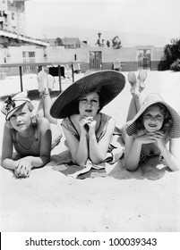 Portrait of three young women lying on the beach