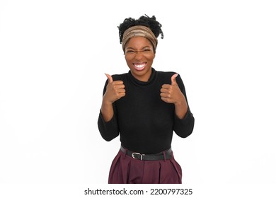 Portrait Of Thrilled African American Woman. Female Model In Turtleneck With Curly Hair Looking At Camera, Showing Thumbs Up. Portrait, Studio Shot, Emotion Concept