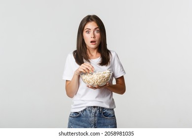 Portrait Of Thrilled And Amazed Young Woman Eating Popcorn And Watching Movies Or Tv Series