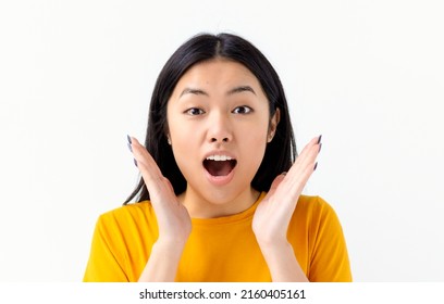 Portrait Of Thrilled Asian Woman With Open Mouth Holding Hands Near Face Isolated On A White Background