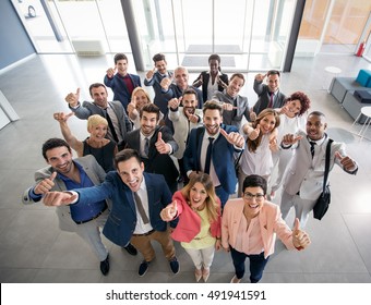 Portrait of thumb up smiling business people