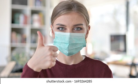 Portrait Of Thumbs Up By Young Woman With Mask