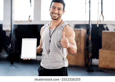 Portrait, thumbs up and man with tablet screen in gym for mockup after exercise. Face, like hand gesture and personal trainer with technology, happy and space for marketing, advertising and fitness. - Powered by Shutterstock