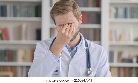 Portrait Of Tired Doctor Rubbing Eyes