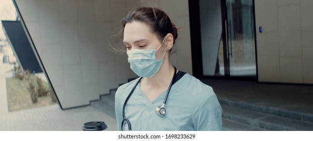 Portrait of tired exhausted nurse or doctor having a coffee break outside in the morning. COVID-19, Coronavirus pandemic - Shutterstock ID 1698233629