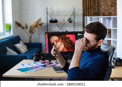 Portrait of tired graphic designer working overtime in office. Stressed worker have eye strain symptoms. Retoucher workplace in photo studio. Burnout and overwork concept. Creative agency. - Powered by Shutterstock