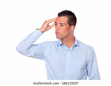 Portrait of a tired latin man on blue shirt with headache standing while is looking at people on isolated background - copyspace