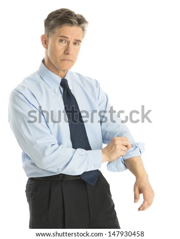 Portrait of tired mature businessman rolling up his sleeves while standing isolated over white background