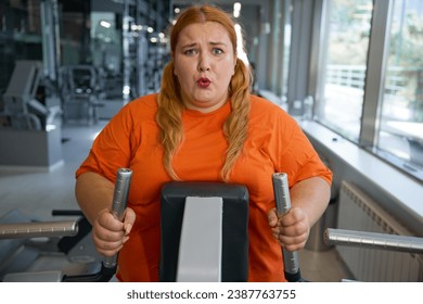 Portrait of tired obese woman working on elliptical machine - Powered by Shutterstock