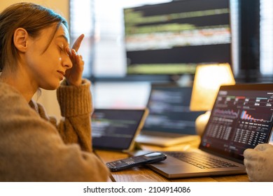 Portrait Of Tired Overworked Woman Sitting At Workplace With Computers. Female Programmer Writing Programming Code At Home Office During Nighttime