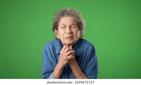 Portrait of tired, sleepy elderly senior old woman hold hands folded in prayer begging about something making wish keep fingers crossed isolated on green screen background studio. - Powered by Shutterstock