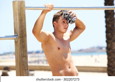 Portrait Of A Tired Sports Man Wiping Sweat Away From Face After Workout