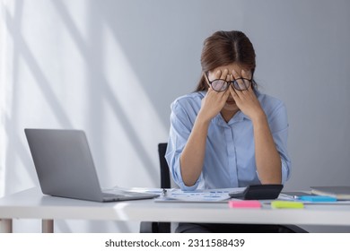 Portrait of tired young business Asian woman work with documents tax laptop computer in office. Sad, unhappy, Worried, Depression, or employee life stress concept - Shutterstock ID 2311588439