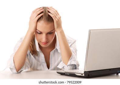 Portrait of a tired young businesswoman in front of a laptop, isolated on white