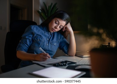 Portrait Of A Tired Young Woman Working Late At Night At Home.