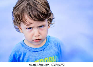 Portrait of toddler boy with angry upset face expression - Shutterstock ID 583750399