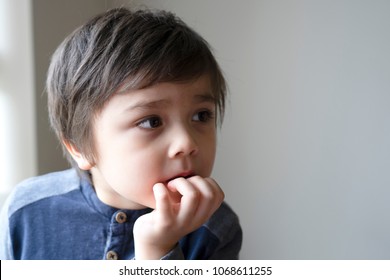 Portrait Of Toddler Boy Biting His Finger Nails With Thinking Face, Childhood And Family Concept, Emotional Child Portrait, Indoor Closeup Face