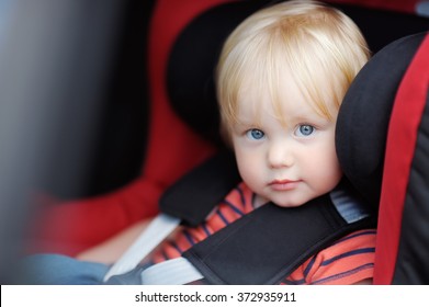 Portrait Of Toddler Boy Sitting In Car Seat