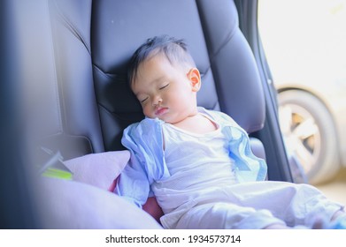 Portrait of toddler boy sleeping in car seat