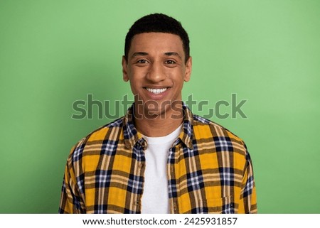 Portrait of toothy smiling handsome happy guy student wearing yellow plaid shirt white teeth model isolated on green color background
