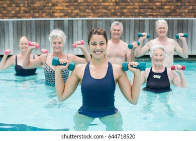 Portrait of trainer with senior swimmers exercising in swimming pool - Powered by Shutterstock