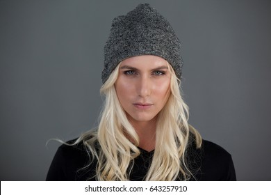 Portrait of transgender woman wearing knit hat gray background - Powered by Shutterstock