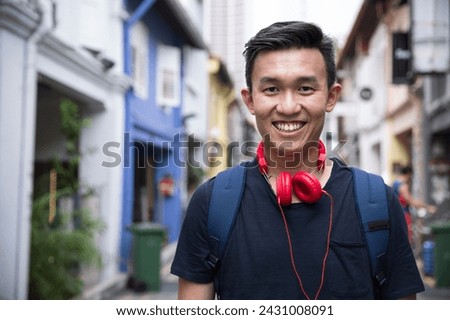 Portrait of a trendy Chinese man lstanding in an urban street.