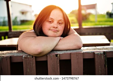 A Portrait Of Trisomie 21 Adult Girl Outside At Sunset