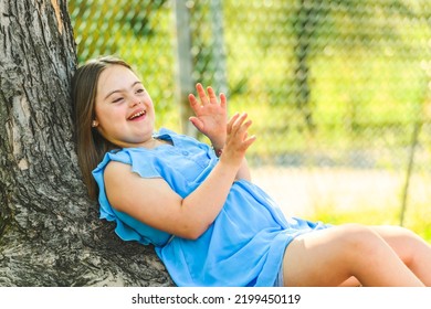 A Portrait Of Trisomy 21 Child Girl Outside Having Fun On A Park